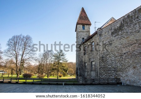 Wall with towers in Tallinn old town, Estonia.  Medieval Tower At sprint. Part Of City Wall. Old Walls. Fortress towers and park on sky background. An old castle with towers surrounds.