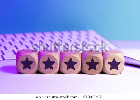Rating system - Stars symbol on a wooden cube in front of a keyboard and a mouse