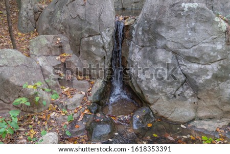A serene waterfall from a small pond.