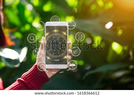 Technology, Mobile phone hand holding with environment Icons over the Network connection on green background.