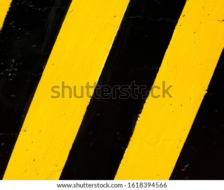 Safety stripes. Warning stripes. Yellow and black diagonal lines on the concrete surface.