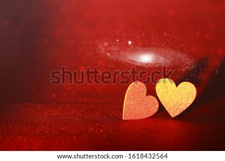 Two glittering hearts on a glittery red background