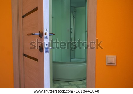 Ajar door to the bathroom with shower. The problem of privacy. Close-up