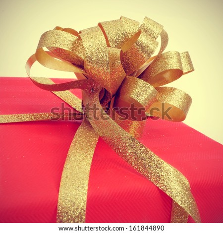 picture of gift wrapped with red wrapping paper and with a golden ribbon, with a retro effect