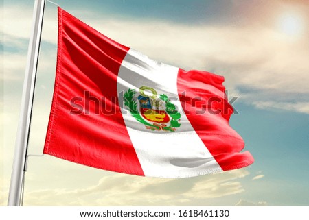 Peru national flag cloth fabric waving on the sky with beautiful sun light