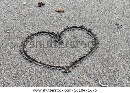 Love sign on the beach. Hand draw love symbol for Valentine’s Day.