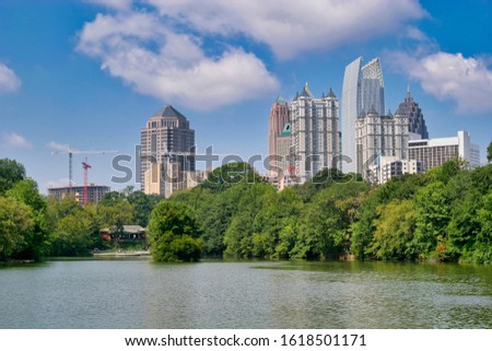 A city skyline beyond a lake in the park