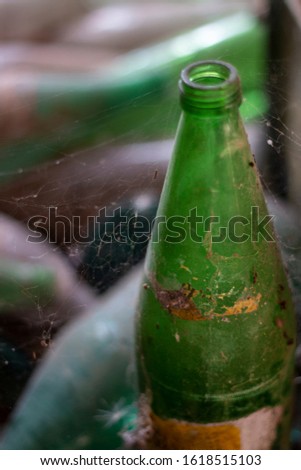 View of a bunch of abandoned beer and soda bottles on a barn.