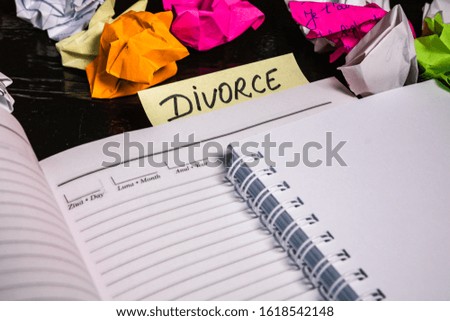 Office desk with agenda, crumpled paper and label with text divorce. Isolated photo. Bucharest, Romania, 2020.