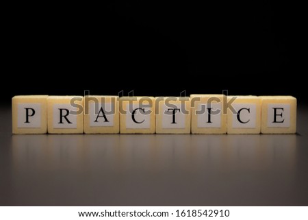 The word PRACTICE written on wooden cubes isolated on a black background