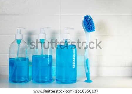 Copy space. Liquid blue soap with dispenser in a plastic bottle and a brush for cleaning ceramics