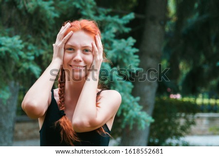 Girl with nordic appearance show emotions outdoor. Woman on blurred green background with copyspace.