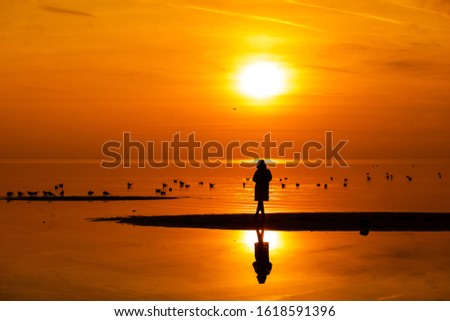 Beautiful Golden sunset. A child walks on the beach by the sea
