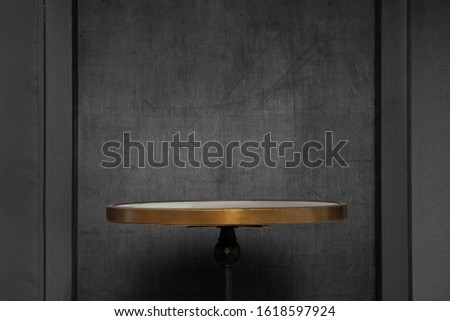 A table in front of a black empty wall