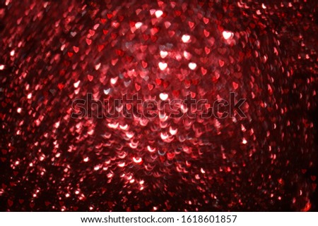 Greeting card for Valentine's Day or Women's Day. Red hearts on abstract blurred red background with bokeh. Festive background, place for text, banner for the screen. Happy birthday, wedding.