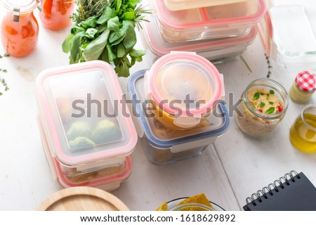 Batch cooking scene. Homemade healthy meal in glass jars on a wooden table. Royalty-Free Stock Photo #1618629892