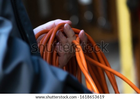 orange extention cord ready to use to plug in electric items Royalty-Free Stock Photo #1618653619