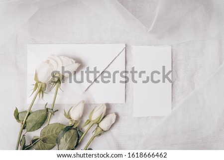 Feminine wedding, birthday mockup scene, baby shower, presentation. Watercolor textured paper greeting cards, white roses. Textile background. Flat lay, top view