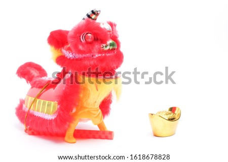 A picture of lion dance miniature with "yuanbao" or sycee for Chinese New Year concept.