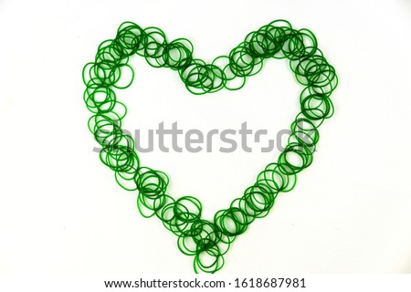Green rubber bands are placed in the shape of a heart on white background.