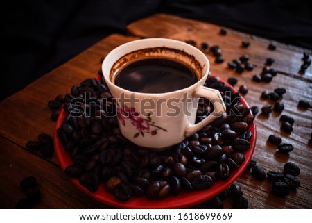 KOPI INDONESIA.Coffee cup and beans on old kitchen table. Top view