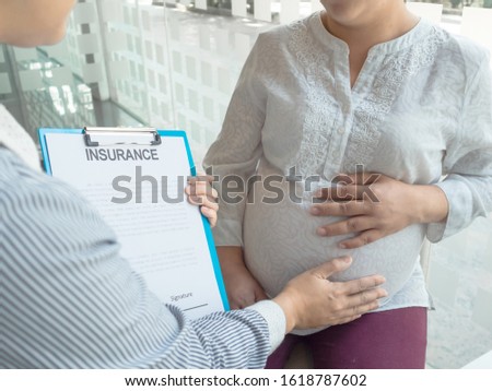 Insurance agent holding chart and explain insurance policy to pregnant Royalty-Free Stock Photo #1618787602