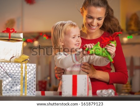 Happy mother and baby opening christmas presents
