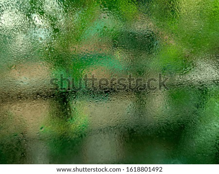 Water droplets on the glass and green leaves