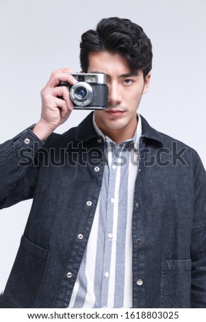 The young man is holding a camera
