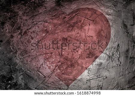 Red heart dissolves on dark grunge background. High contrast image. Template for love message, conceptual image.