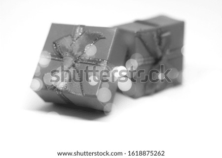 Black and white gift boxes on white background with bokeh effect.