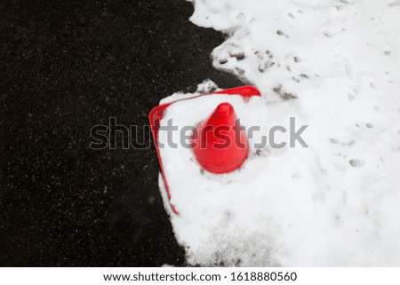 Traffic cone in the snow on the road. Winter season. 