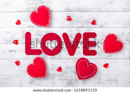Word Love and red hearts on white wooden background Red textile letters. Valentines Day greeting card - Image