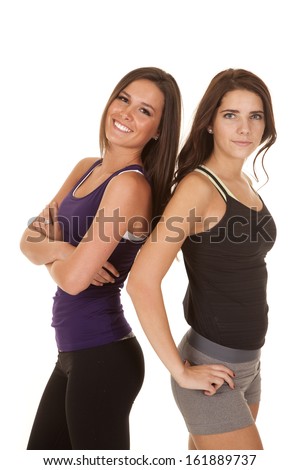 Two women are standing back to back in fitness clothes.