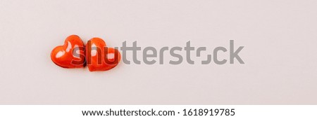 Beige banner with two glossy hearts. Design for Valentine's day.