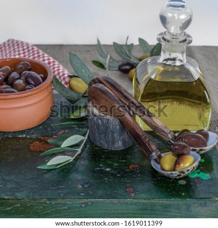 Olives. Kalamata Greek olives in glass container and   seashell shaped spoons.  Ceramic small bowl on far left. Stock Image.