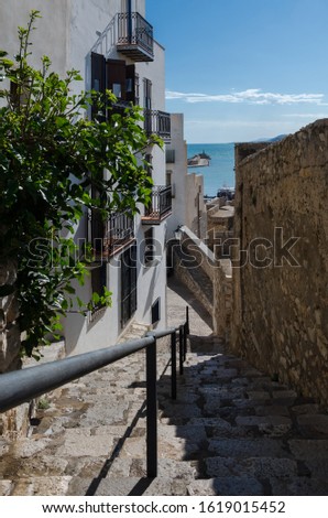 Strolling through the medieval town of Peñíscola in the morning with its white houses and its picturesque streets and the blue mediterranean sea in the background, Castellón, Spain