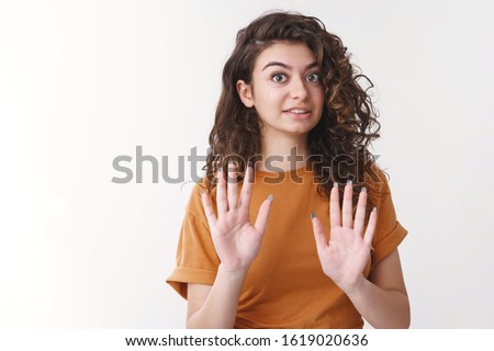 No thank you. Portrait uncomfortable awkward young curly-haired woman raise palms rejection apology gesture really sorry cannot attend party declining invitation, standing white background Royalty-Free Stock Photo #1619020636