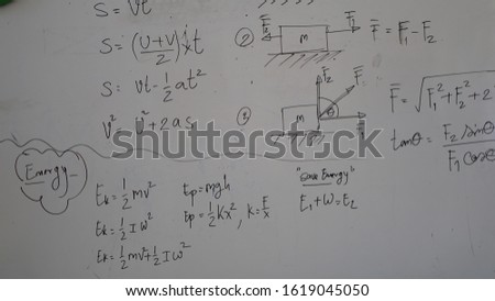 Physics formulas were written with handwriting of teacher on the whiteboard to teach in Physics subject at school. Concept, education. Teaching approach style. Formulas for calculation to  solutions.