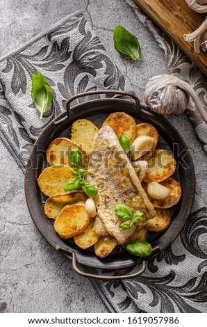 Delicious fish with roasted potatoes and bio garlic