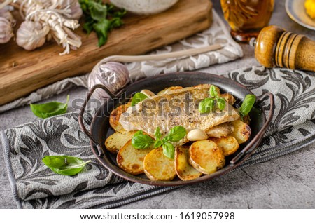 Delicious fish with roasted potatoes and bio garlic