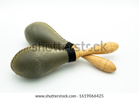 Closeup of a pair of rawhide maracas lying on a white underground