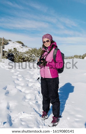 Woman in the High Snowy Mountain with Photo Camera.Winter Vacation Concept .Photographer in the Mountain 