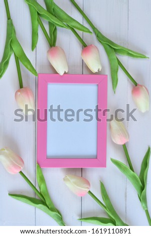 photo frame and flowers on a pink background.tulip.Copy space in the middle for your text.Womans day concept.Concept of beauty blog