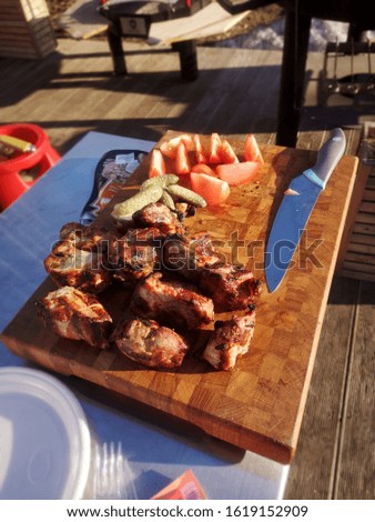 On the grill are roast pieces of meat, smoke is coming and red coals are visible