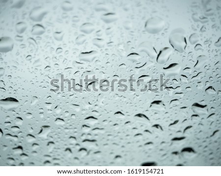 Close up view of water drops falling on glass