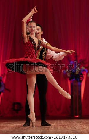 Duet young girl ballerina and a young man dancing ballet performance on stage in a theater