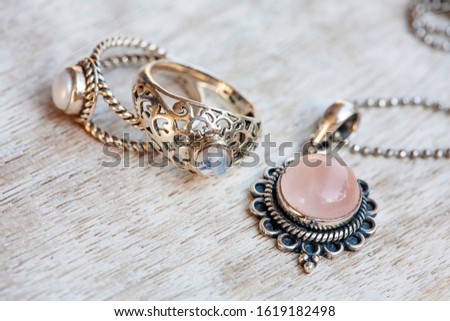 Silver jewelry on neutral bright wooden background Royalty-Free Stock Photo #1619182498