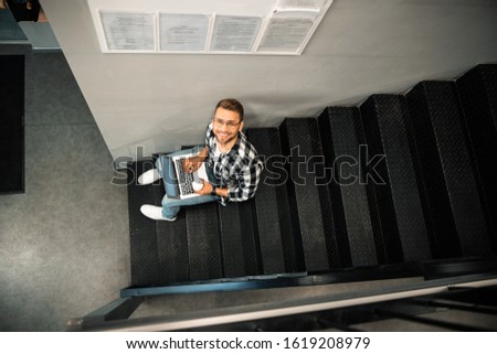 Top view of smiling male blogger working with laptop and enjoying hot drink stock photo