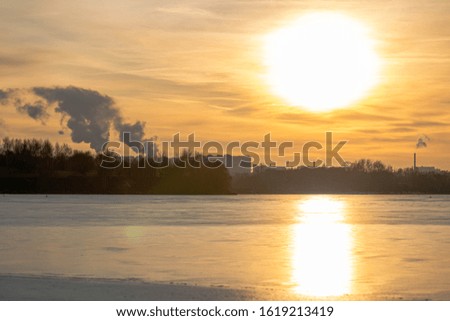 Winter sunset on the background of a frozen pond, lake. Moscow. Russia.